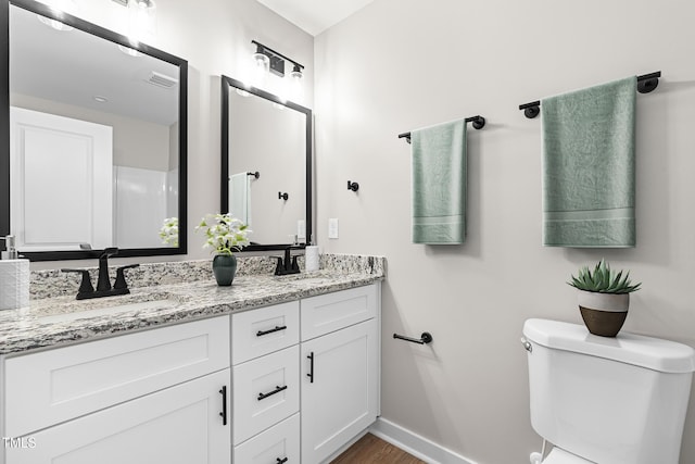 full bathroom with toilet, baseboards, visible vents, and a sink