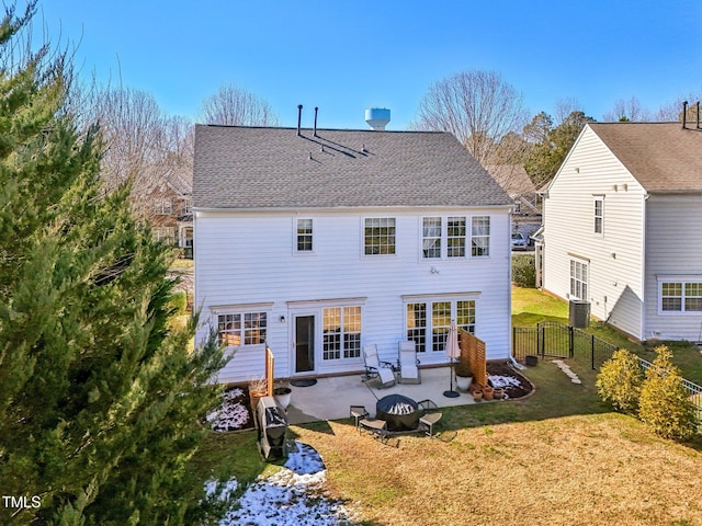 back of property with roof with shingles, a yard, an outdoor fire pit, a patio area, and fence