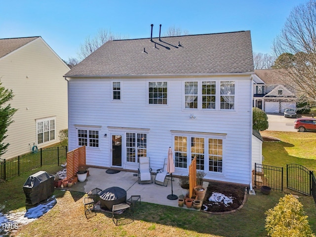 rear view of house with a patio, a lawn, and fence