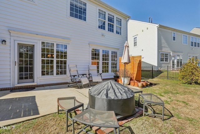 back of property with a patio, a lawn, and fence