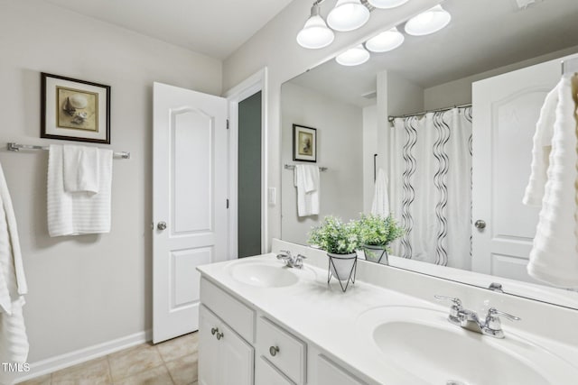 full bathroom featuring double vanity, tile patterned flooring, baseboards, and a sink