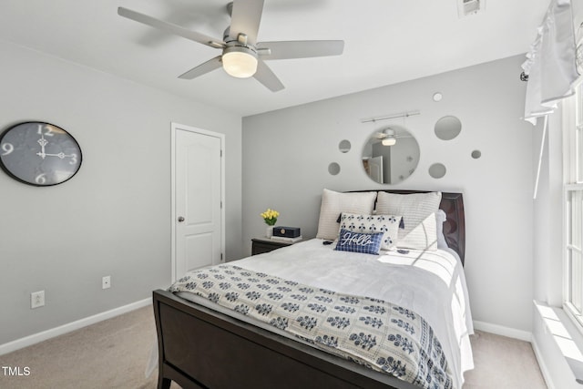 bedroom with light carpet, a ceiling fan, visible vents, and baseboards