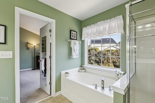 full bath with a shower with shower door, tile patterned flooring, a bath, and baseboards