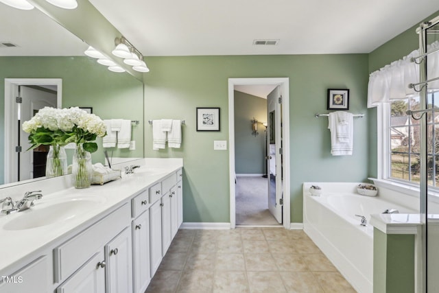 full bathroom featuring a garden tub, tile patterned flooring, a sink, visible vents, and double vanity