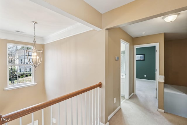 corridor featuring crown molding, light colored carpet, an upstairs landing, a chandelier, and baseboards