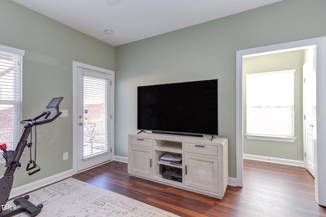 workout area with dark wood-style flooring, a healthy amount of sunlight, and baseboards