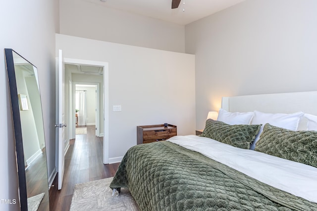 bedroom with dark wood-type flooring, a ceiling fan, and baseboards