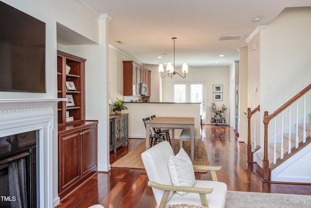 dining area featuring visible vents, stairway, dark wood-type flooring, an inviting chandelier, and crown molding