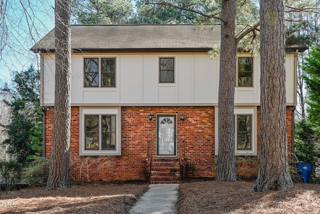 view of front facade featuring entry steps, board and batten siding, and brick siding