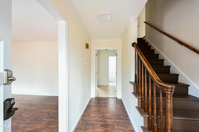 interior space featuring stairs, baseboards, dark wood finished floors, and crown molding