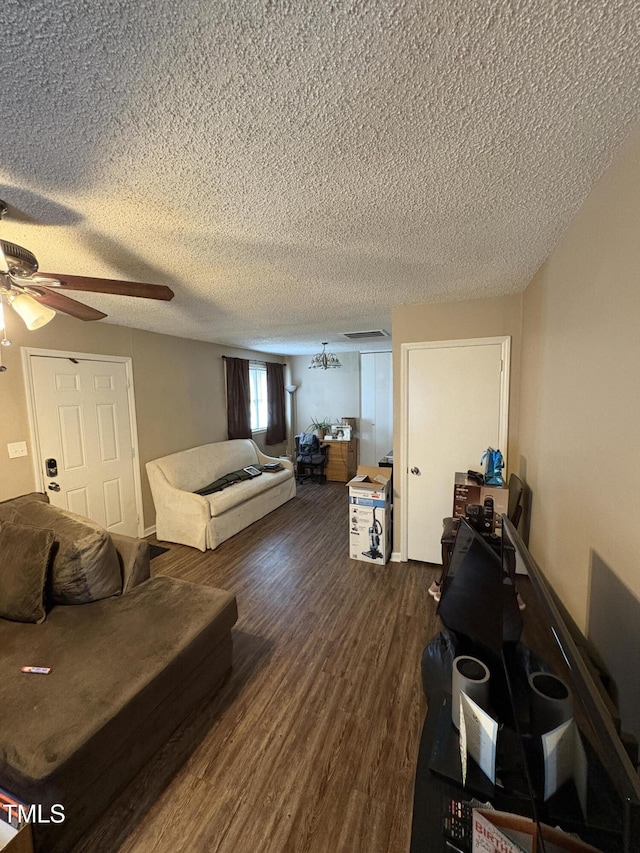 living room with a textured ceiling, dark wood finished floors, and a ceiling fan