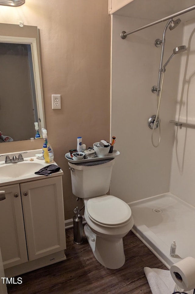 bathroom featuring a stall shower, vanity, toilet, and wood finished floors