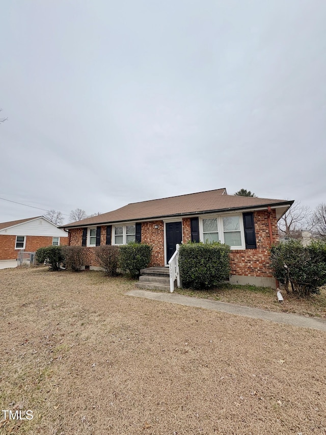 ranch-style house with a front yard and brick siding