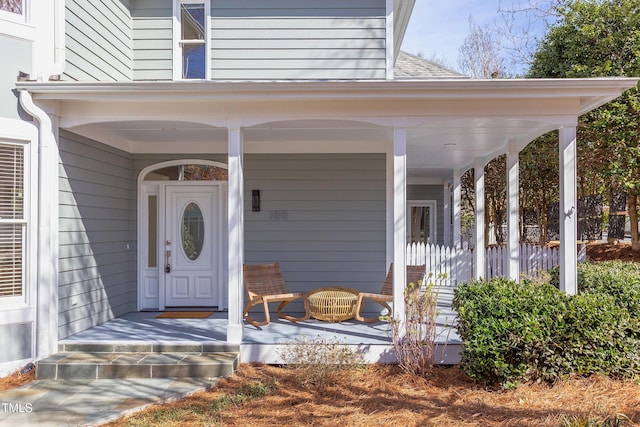 doorway to property featuring a shingled roof and a porch