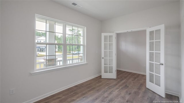 empty room featuring french doors and hardwood / wood-style floors