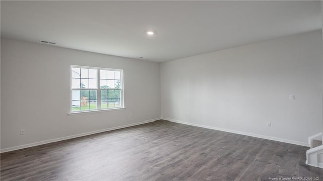 unfurnished room with dark wood-type flooring