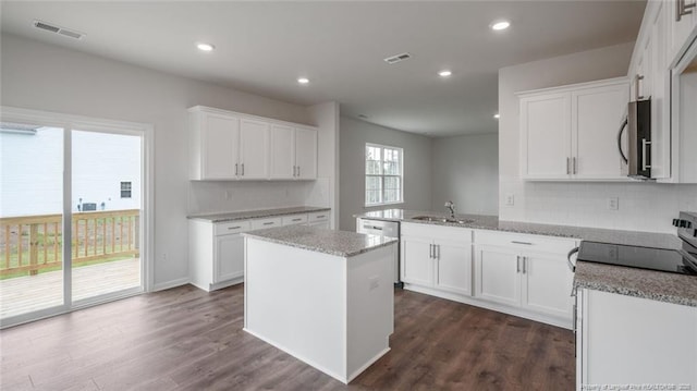 kitchen with sink, stainless steel appliances, white cabinetry, and kitchen peninsula