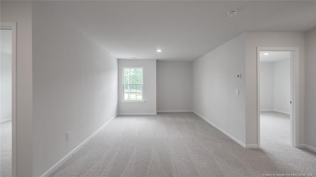 spare room featuring light colored carpet