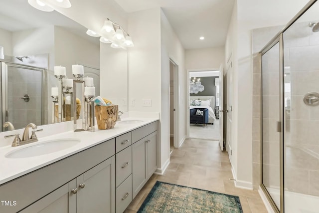 ensuite bathroom featuring double vanity, a stall shower, connected bathroom, a sink, and tile patterned floors