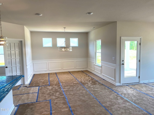 unfurnished dining area with a wainscoted wall and a decorative wall