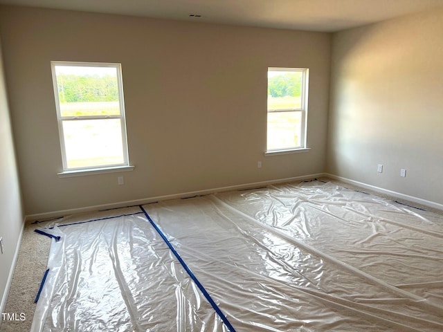unfurnished room with baseboards