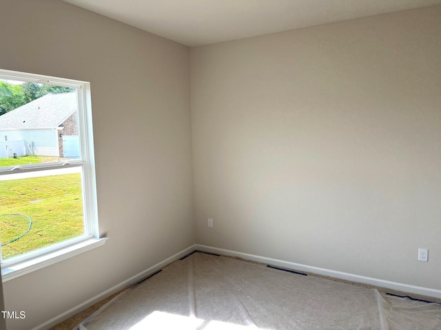 carpeted spare room featuring baseboards