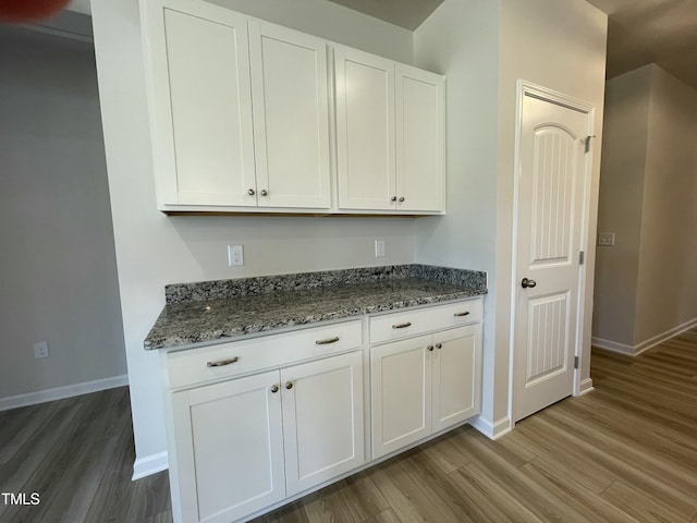 316 Olivia Crossing Ct Unit 11, Four Oaks, NC 27524 - kitchen with light wood-style flooring, baseboards, and stone counters