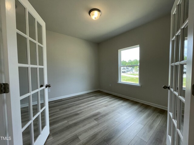 316 Olivia Crossing Ct Unit 11, Four Oaks, NC 27524 - empty room featuring french doors, wood finished floors, and baseboards