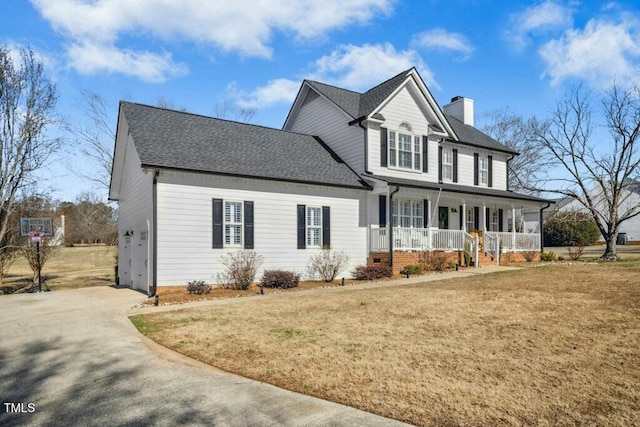 traditional-style home featuring roof with shingles, a chimney, a porch, a front yard, and driveway