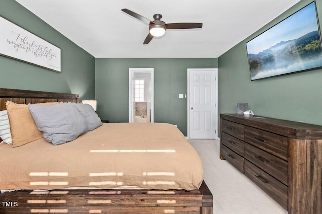 bedroom with light carpet, ceiling fan, and ensuite bath