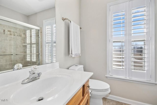 bathroom with toilet, vanity, a shower stall, and a wealth of natural light