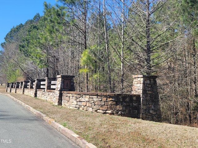 community sign featuring a wooded view