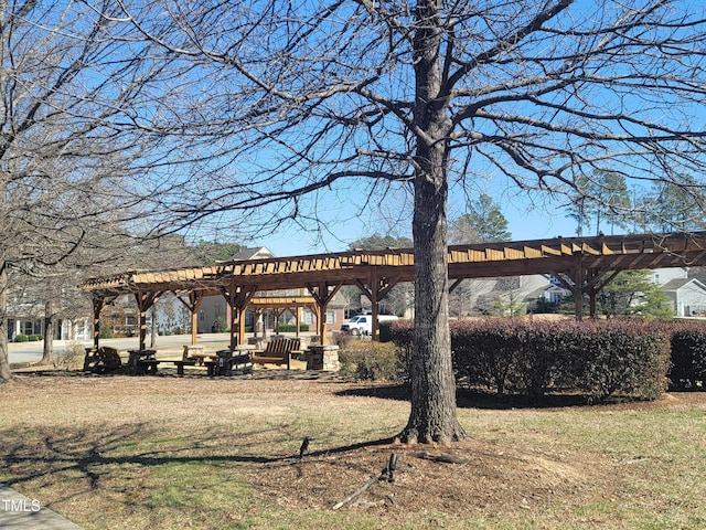 surrounding community featuring a lawn and a pergola