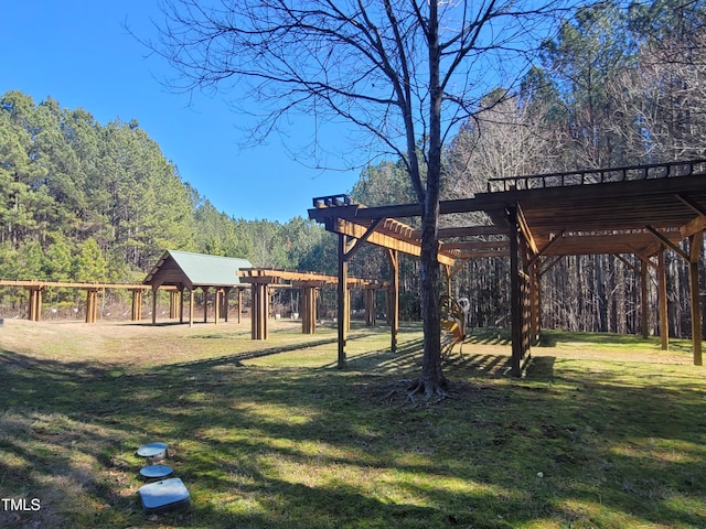 view of yard with a wooded view and a pergola