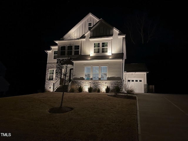 view of front of property featuring an outdoor structure, a garage, board and batten siding, and stone siding