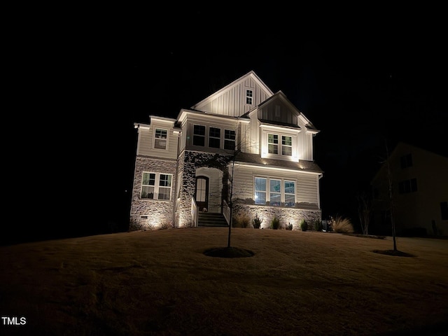 view of front of property with stone siding, board and batten siding, and a yard