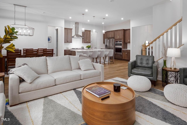 living room featuring recessed lighting, stairs, and light wood-style floors