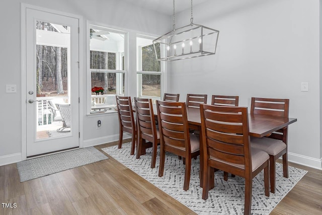 dining space with baseboards and wood finished floors