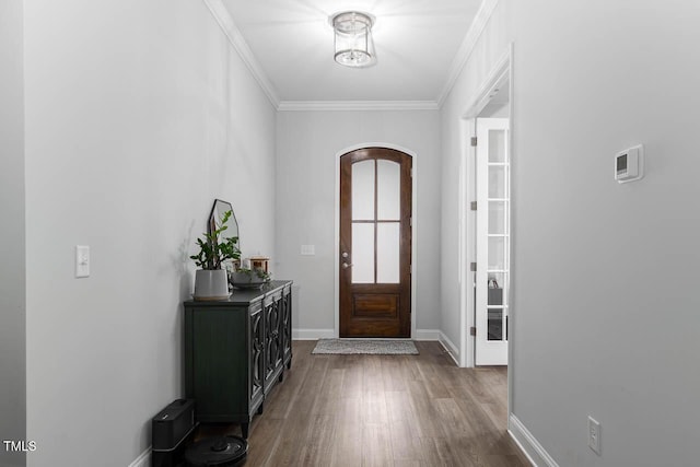 foyer with crown molding, baseboards, and wood finished floors