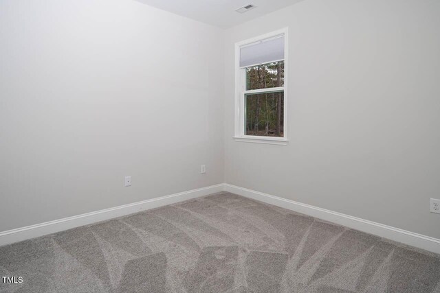 carpeted spare room with baseboards and visible vents