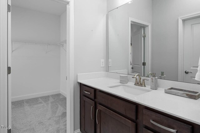 bathroom featuring vanity and a walk in closet