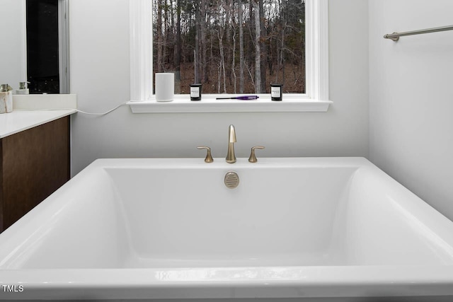 bathroom with a freestanding tub and vanity