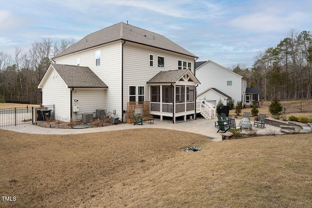 rear view of house with fence, an outdoor fire pit, central AC, a sunroom, and a patio area