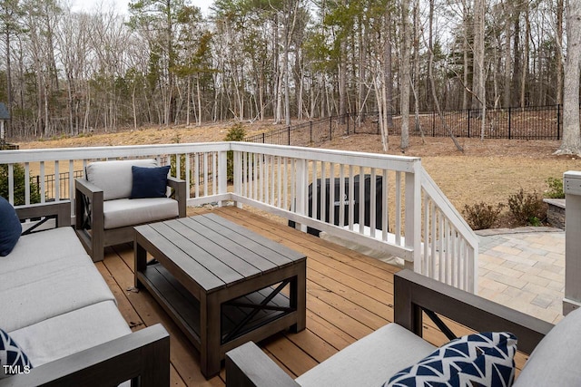 wooden deck featuring an outdoor hangout area and fence