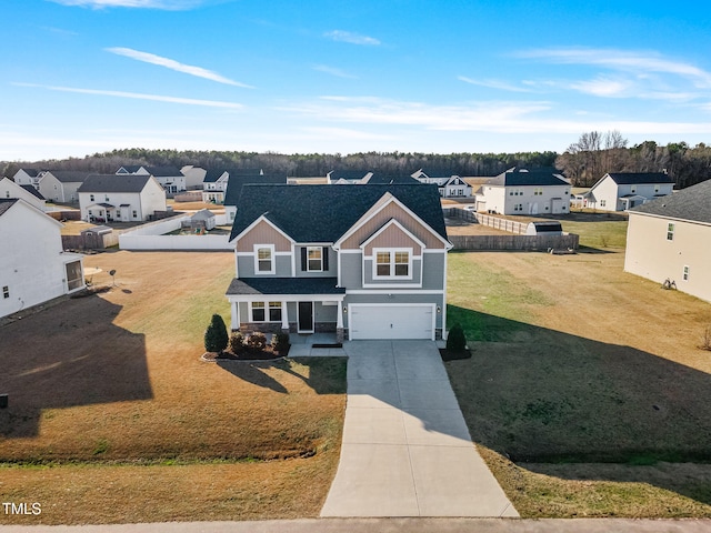 traditional home with driveway, an attached garage, a residential view, and a front lawn