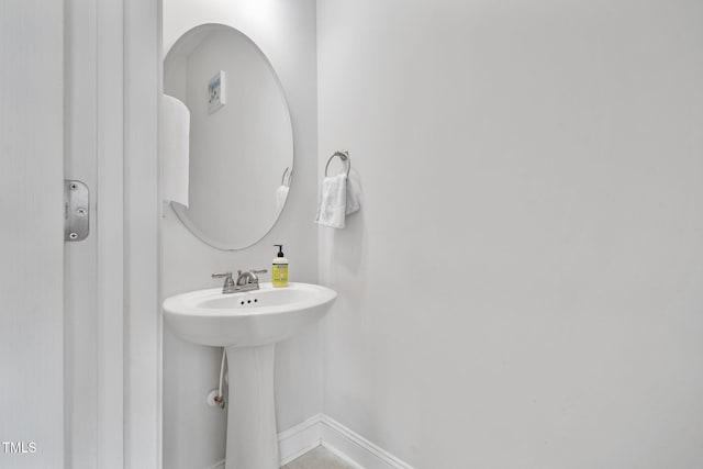 bathroom featuring baseboards and a sink