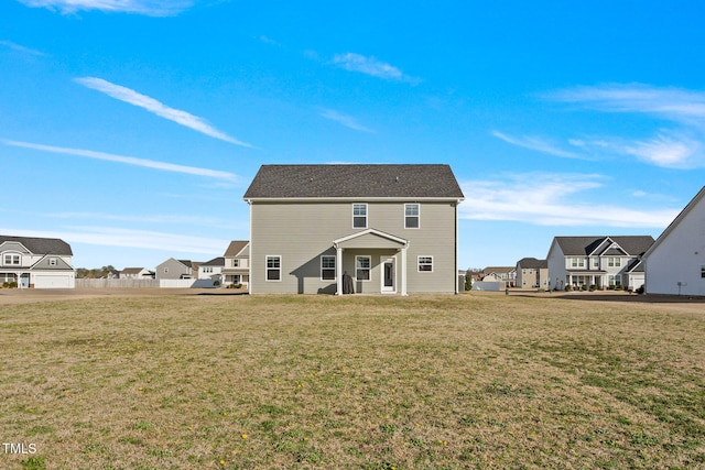 back of house with a yard and a residential view