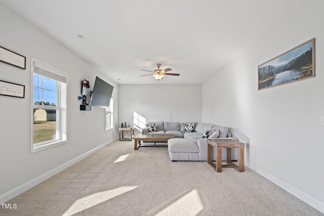 carpeted living room featuring ceiling fan and baseboards
