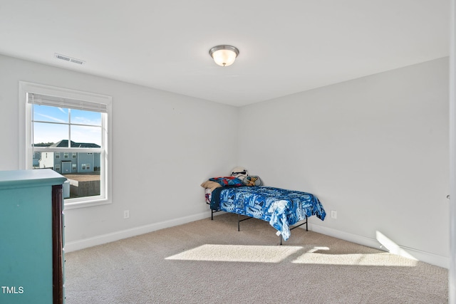 bedroom with baseboards, visible vents, and carpet