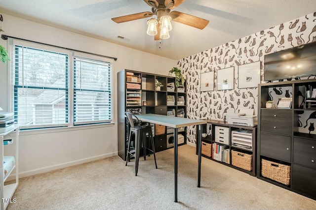 office space with a textured ceiling, ceiling fan, light colored carpet, visible vents, and baseboards